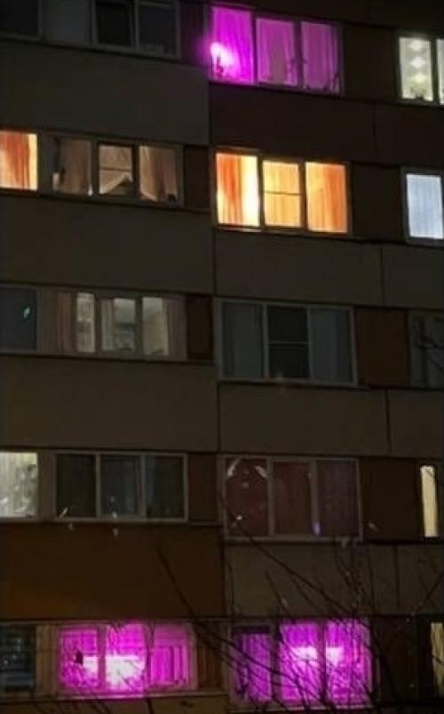 В сети завирусилась фотография дома, где сразу несколько окон светятся ярко-фиолетовым светом. 02