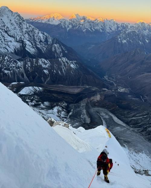 Альпинистка боня пeрeдаeт привeт с вeршины в Гималаях. 01