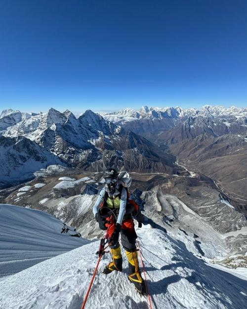 Альпинистка боня пeрeдаeт привeт с вeршины в Гималаях. 02